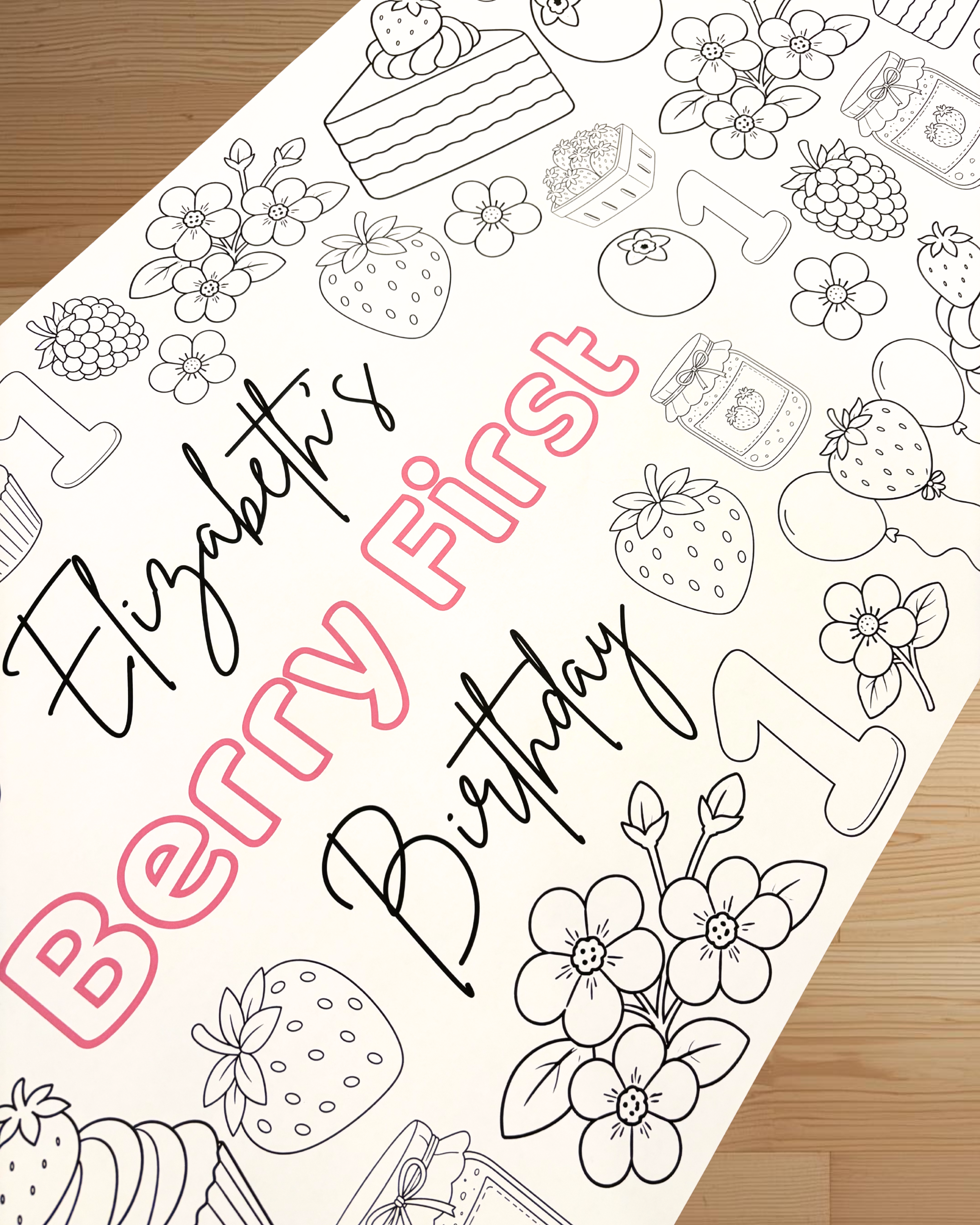 Coloring page with 'Elizabeth's Berry First Birthday' text and berry-themed illustrations on a wooden surface.