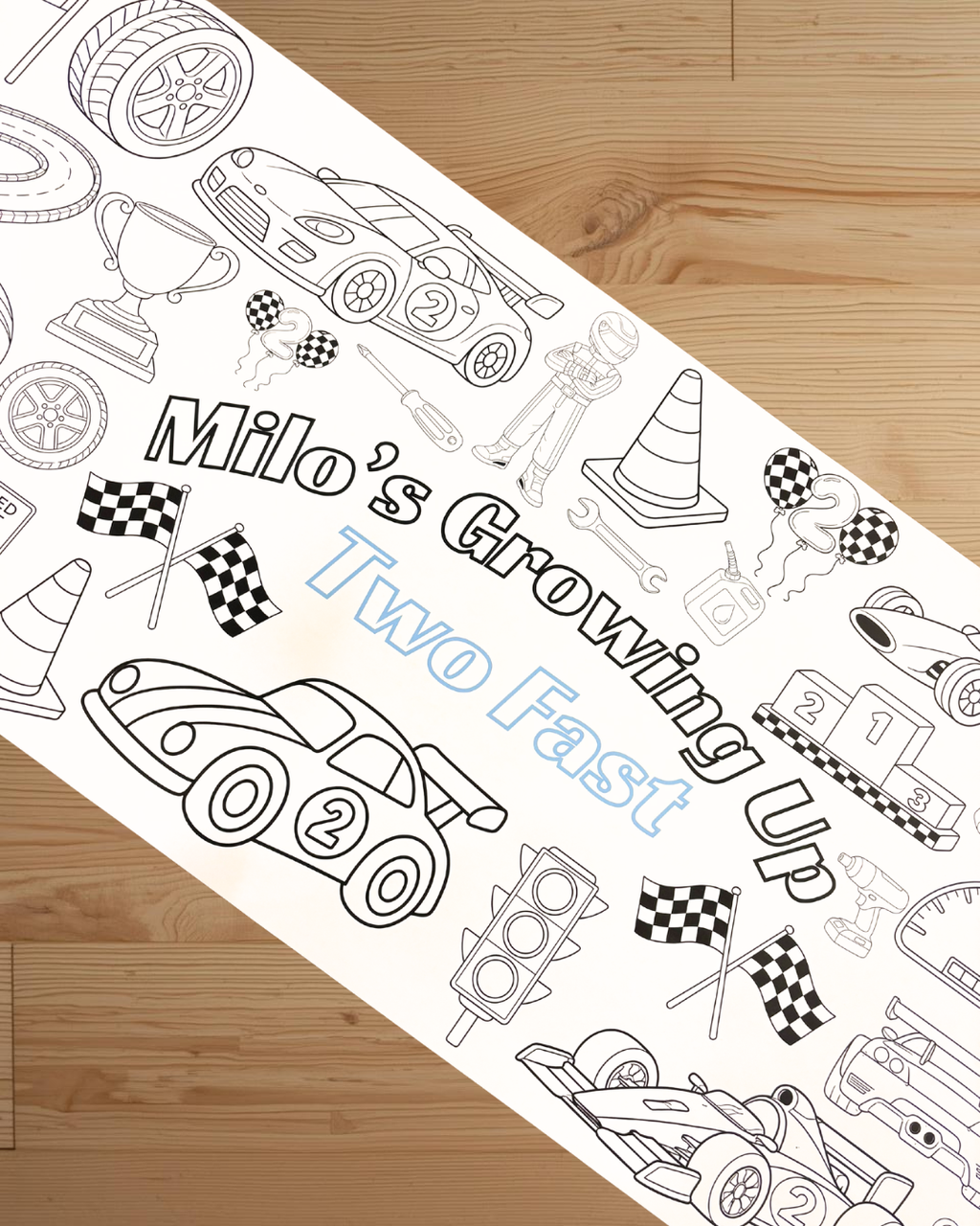 Coloring sheet with race car theme and text 'Milo's Growing Up Two Fast' on a wooden surface.
