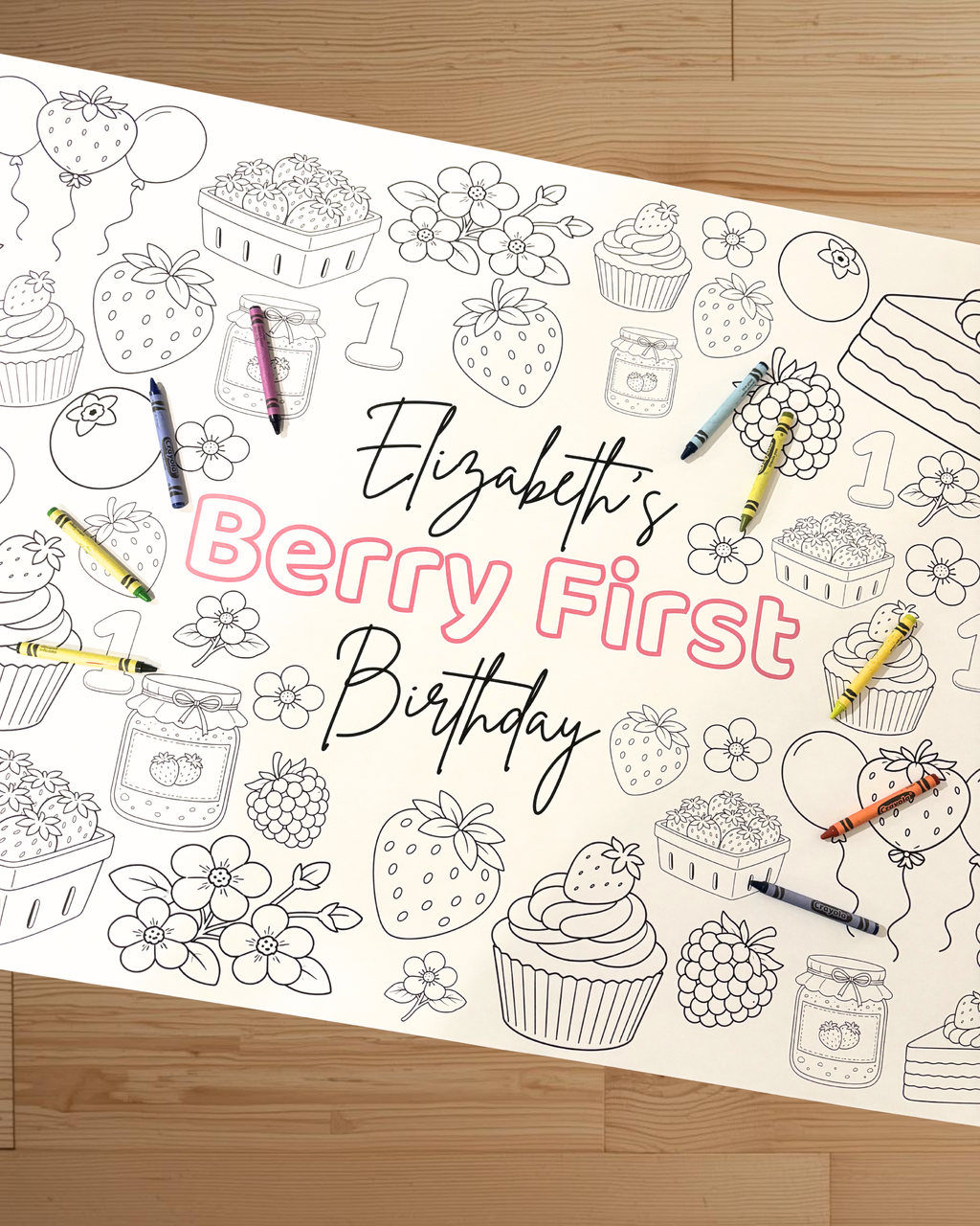 Coloring sheet with strawberry-themed birthday design on a wooden surface